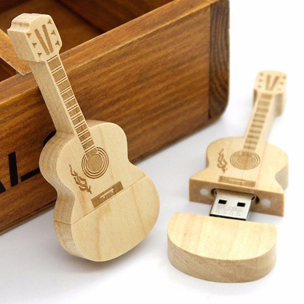Une clé USB bois en forme de Guitare Une clé USB en bois à l'esprit musical, très originale et réalisée en bois de bambou, le matériau le plus écologique.  Clé USB Guitare livrée avec son porte clé et dans sa boite en bois, idéale pour offrir ou se faire plaisir !
