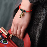 Magnifique bracelet ethnique,  tressé et entièrement réalisé à la main,  cloche et fermoir plaqués Or.  Deux petits anneaux plaqués or entourant 2 perles de jade Rouge. 