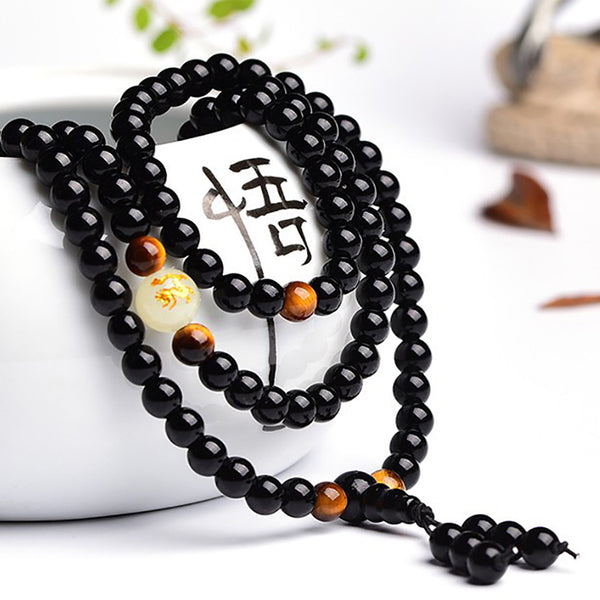 Superbe bracelet Dragon Noir, Perles naturelles, œils de tigre, et en son centre la pierre lumineuse du dragon.